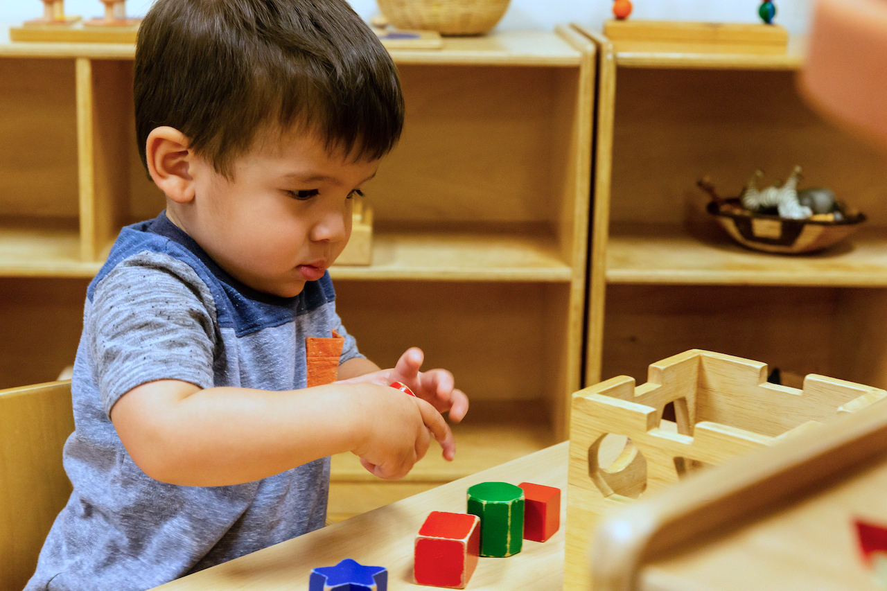 Boy playing with puzzles La Jolla Montessori School