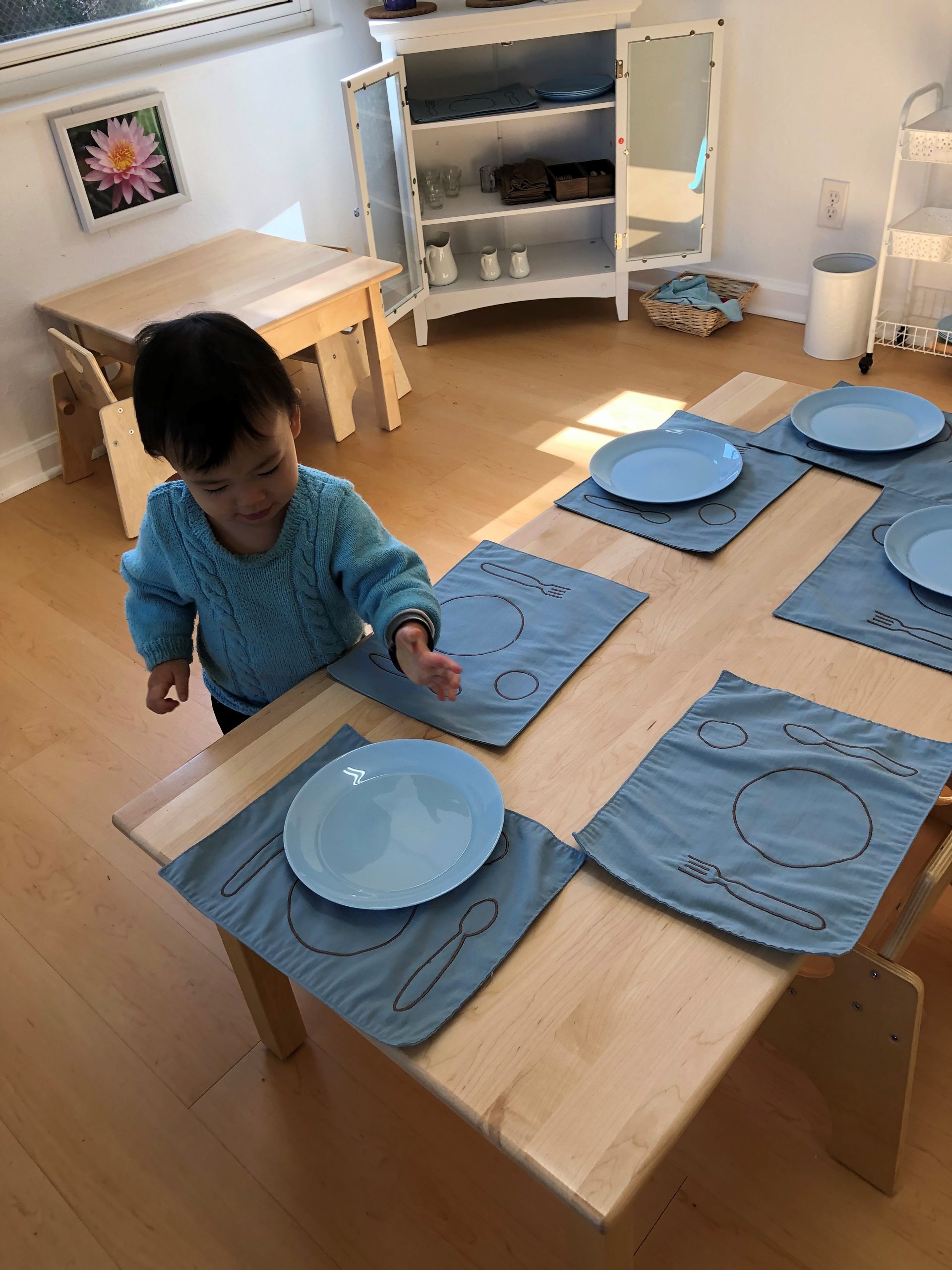 Toddler setting the table for lunch