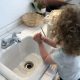 Toddlers learn how to wash their hands with a child size sink