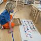 Girl learning how to put words together in cursive in Primary Classroom at La Jolla Montessori school