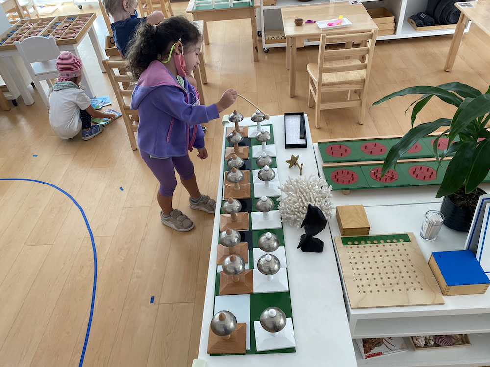 Girl playing with bells in Primary Classroom at La Jolla Montessori school