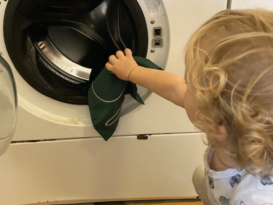 Toddler Doing Loading the Washing Machine at La Jolla Montessori School