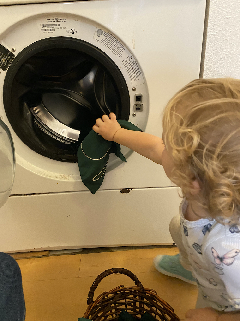 Toddler Doing Loading the Washing Machine at La Jolla Montessori School