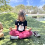 Niño Montessori meditando mientras hace yoga para apoyar la salud y el bienestar en La Jolla Montessori School