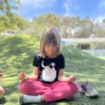 Montessori child meditating while doing yoga to support health and wellness at La Jolla Montessori School
