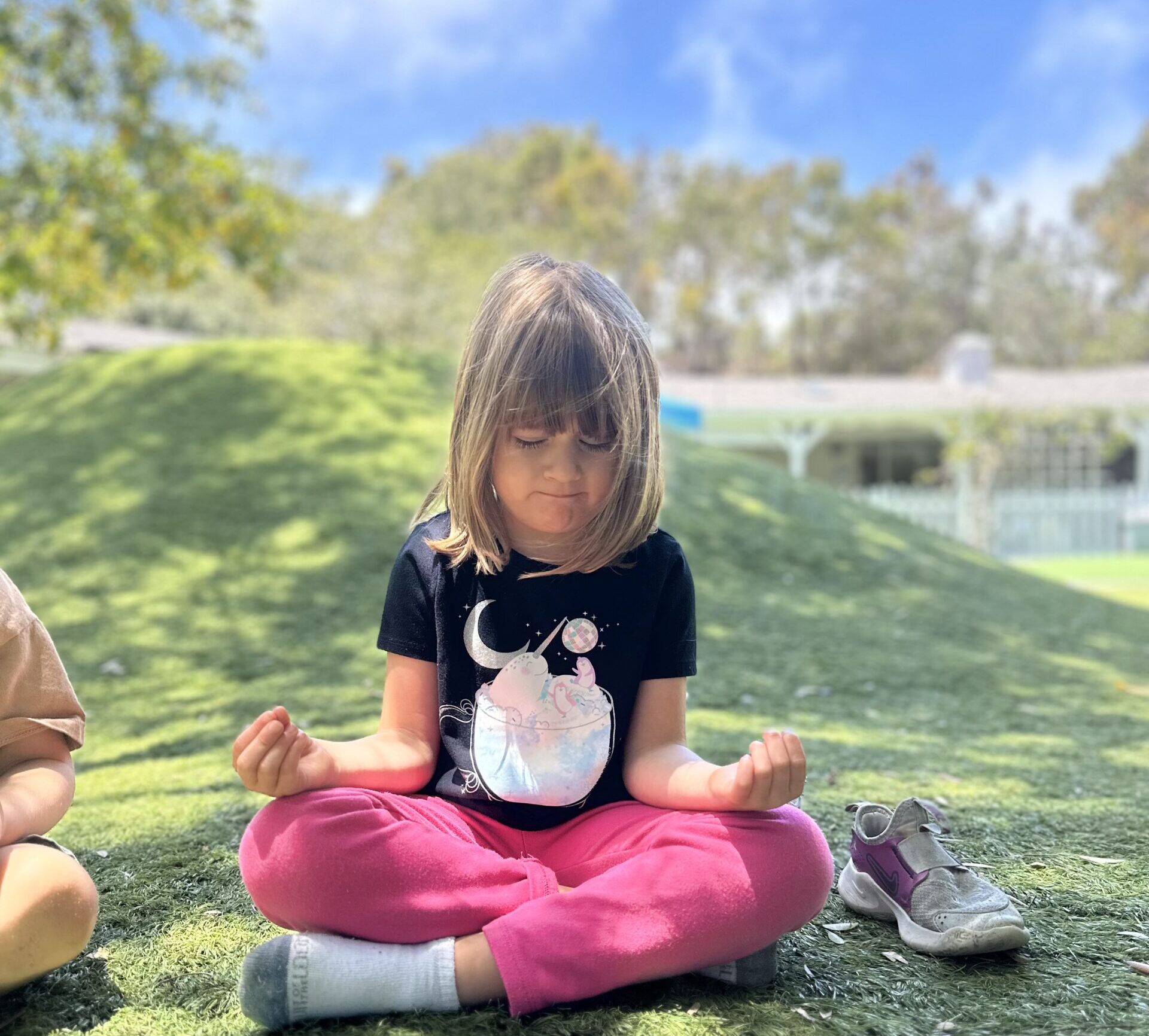 Montessori child meditating while doing yoga to support health and wellness at La Jolla Montessori School