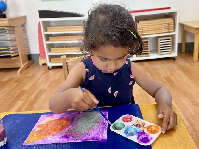 Montessori Child painting and relaxing at La Jolla Montessori School