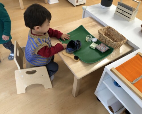 Toddler cleaning his shoes independently