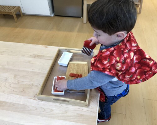 Toddler cutting fruit independently