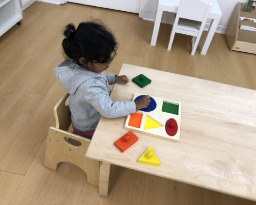 Toddler solving wooden puzzle
