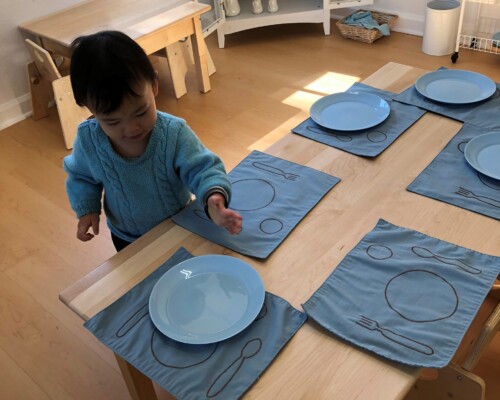 Toddler setting the table for lunch