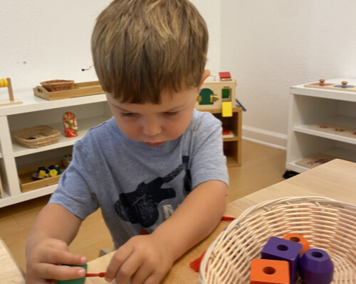 Boy playing with shapes and colors in Preschool