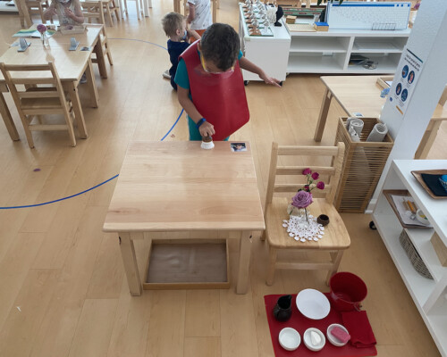 Niño limpiando su pupitre en un aula multiedad